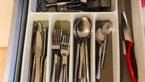 A drawer containing various silverware including forks, knives, spoons, and a butter knife.