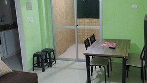 Comedor con mesa, sillas y ventilador de techo. Hay una puerta corrediza de vidrio que da a un espacio exterior.