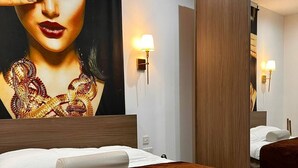 Ein Hotelzimmer mit einem großen Bett, einem hölzernen Kopfteil, einer Wandlampe und einem großen Spiegel.