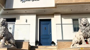 Ein Gebäude mit einer blauen Tür, zwei Löwenstatuen an der Seite des Eingangs und einem Schild über der Tür mit der Aufschrift "The Fort".