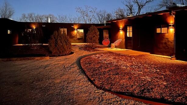 A building at night with a gravel driveway and a pathway leading to the entrance. - Dreamy, Airy 2bd - Senja Suite @ La Dea (Santa Fe)