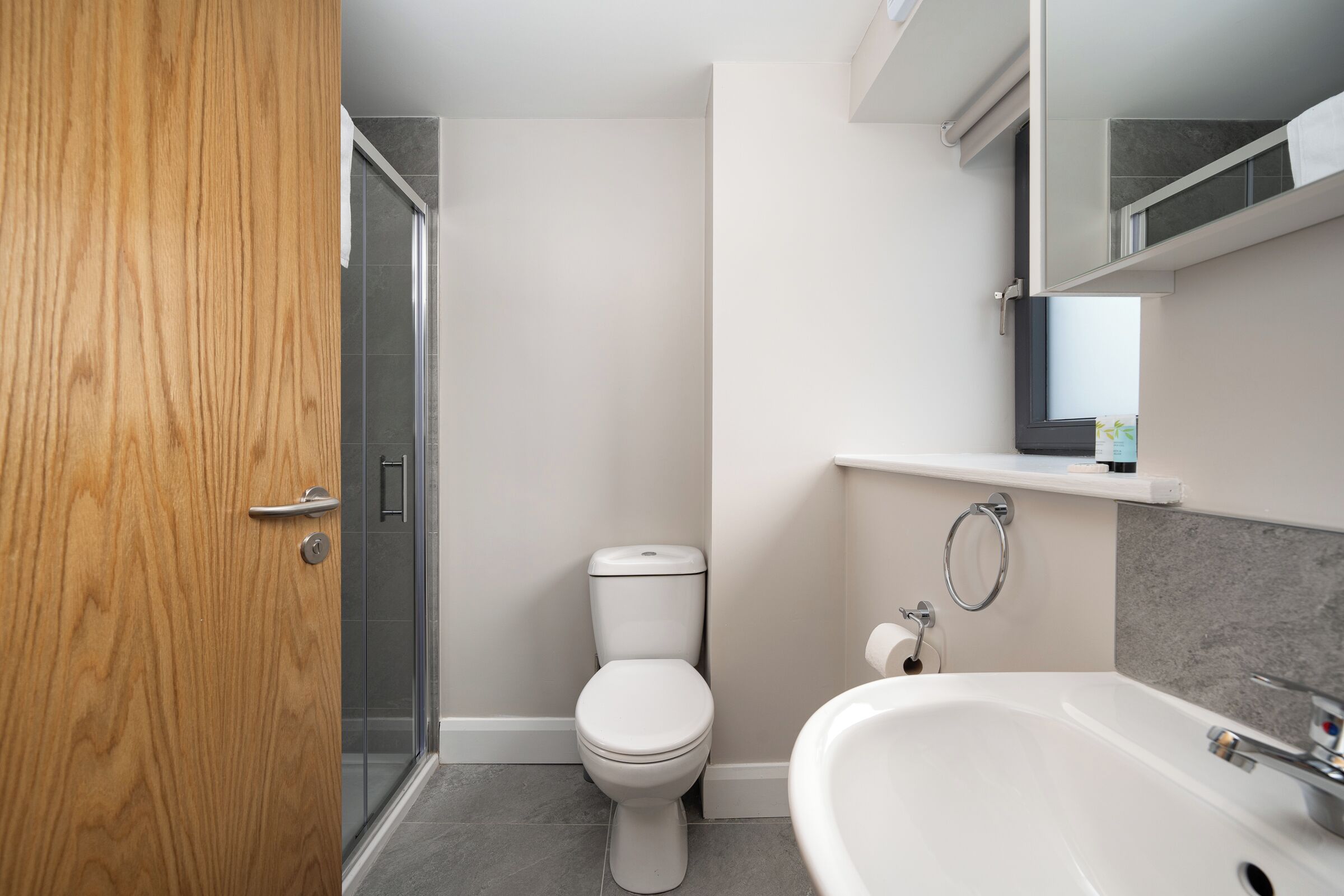 Une salle de bain moderne équipée de toilettes, d’une douche et d’un lavabo.