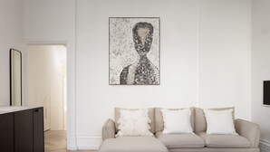A modern living room with a minimalist design, featuring a sofa set and a large abstract artwork on the wall. - Sophisticated Notting Hill 2bed (London)