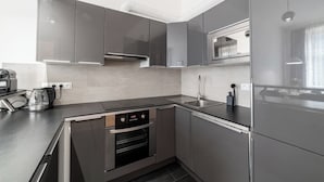 Una cocina moderna con electrodomésticos de acero inoxidable, horno integrado y microondas.
