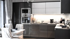 A modern kitchen with stainless steel appliances, a dining area with a table and chairs, and a chandelier. - Lovely Family Suite (Apart534), Lovely family suite: luxurious modern apartment with private garden (Prague)