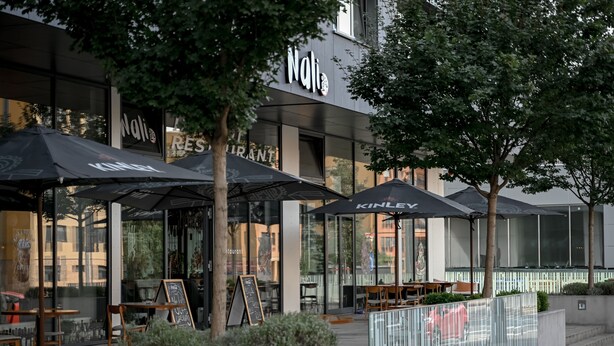 An outdoor seating area with umbrellas, a sign reading "Nali Restaurant," and a no parking sign. - Lovely Family Suite (Apart534), Lovely family suite: luxurious modern apartment with private garden (Prague)