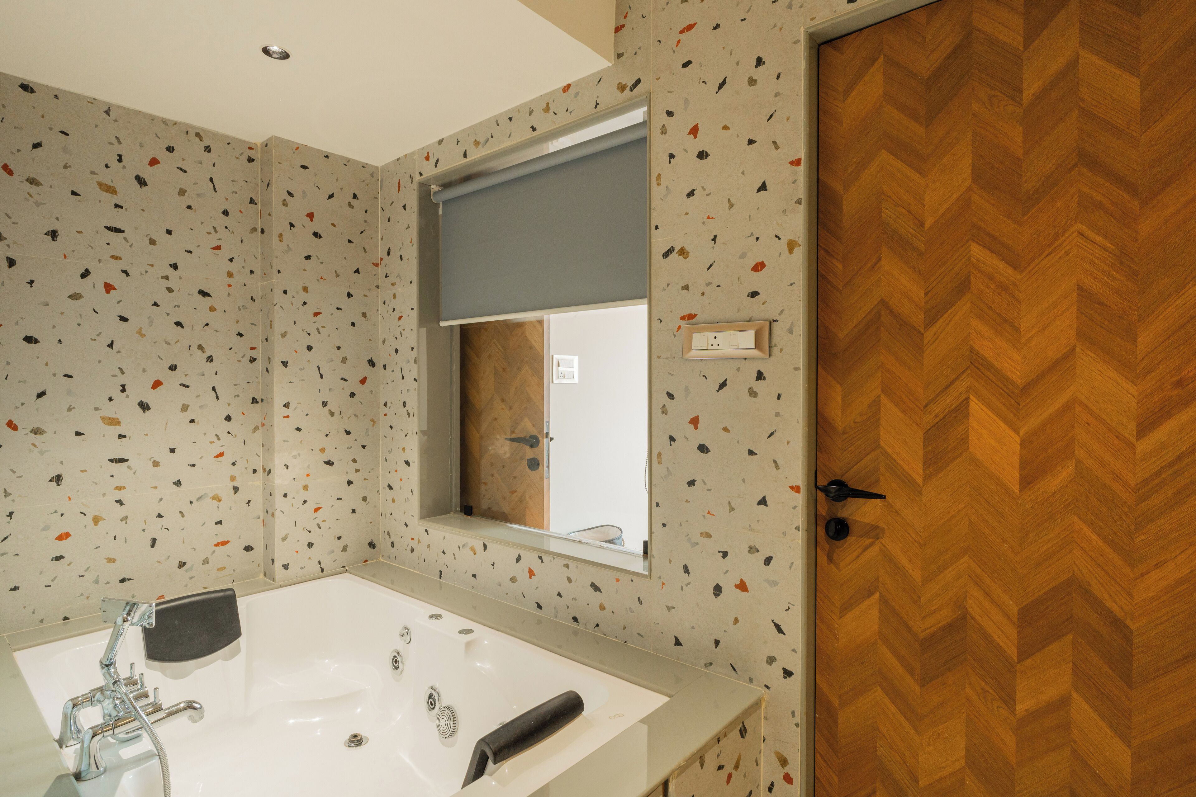 A bathroom with a white sink, a mirror, and a wooden door.
