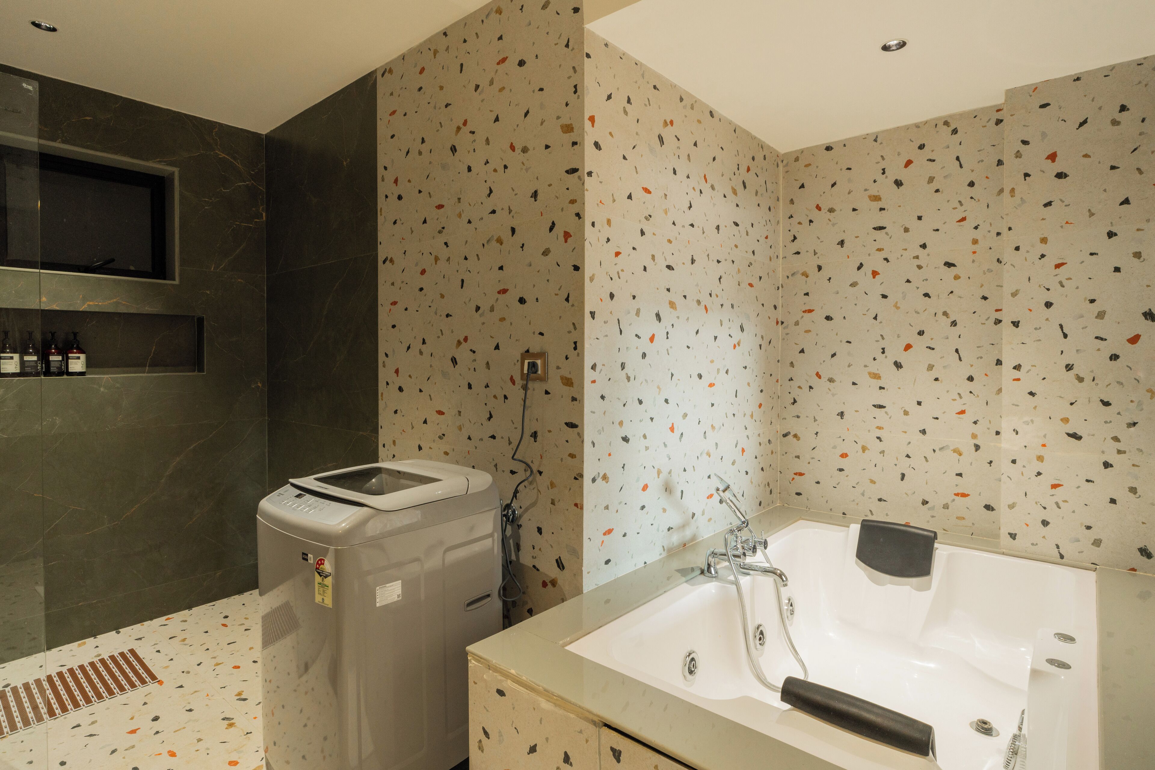 Un baño moderno con una bañera independiente, ducha integrada y tocador de mármol.