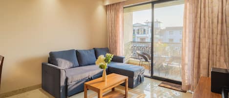 Departamento, 1 cama King size, balcón, vista a la ciudad | Área de sala de estar | Televisión de pantalla plana