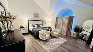 Une chambre à coucher moderne avec un lit, des tables de chevet, une chaise, un miroir et une plante en pot.