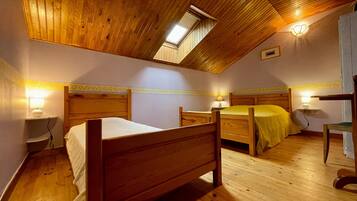 Ein Schlafzimmer mit zwei hölzernen Betten, einem Oberlicht und Nachttischlampen.