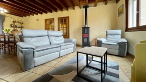 A cozy living room with a sofa, armchairs, a coffee table, and a fireplace. - Lilas Room in Alleyras - Pets allowed, Guest table, Spacious grounds (Alleyras)