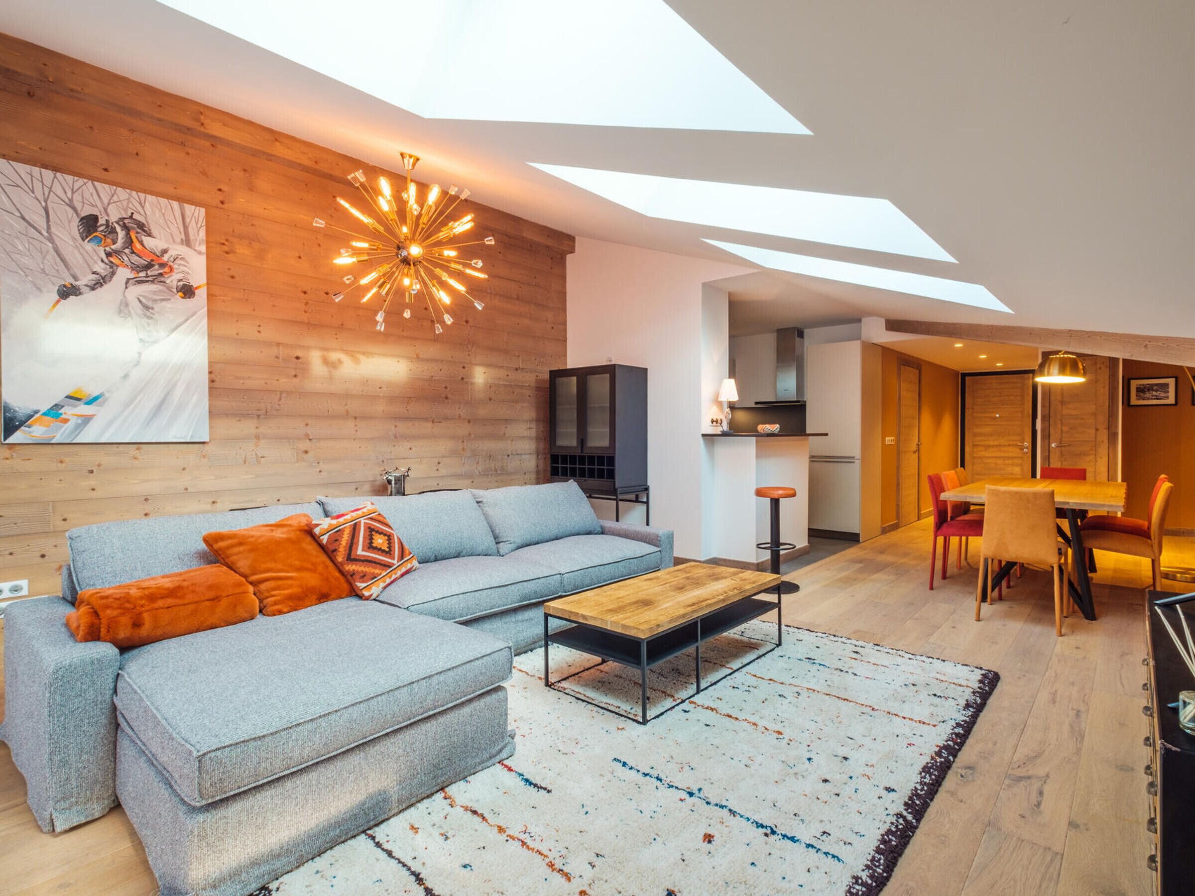 A modern living room with a sectional sofa, a coffee table, and a large painting on the wall.
