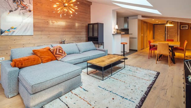 A modern living room with a sectional sofa, a coffee table, and a large painting on the wall. - New apartment in Les Gets, 3 bedrooms, mountain view, parking (Les Gets)