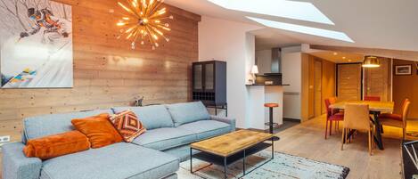 A modern living room with a sectional sofa, a coffee table, and a large painting on the wall.