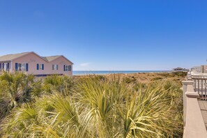 A beachfront property with a pink house, a wooden deck, and a view of the ocean. - 2 Blocks to Shore: Atlantic Beach Home w/ Views! (Atlantic Beach)