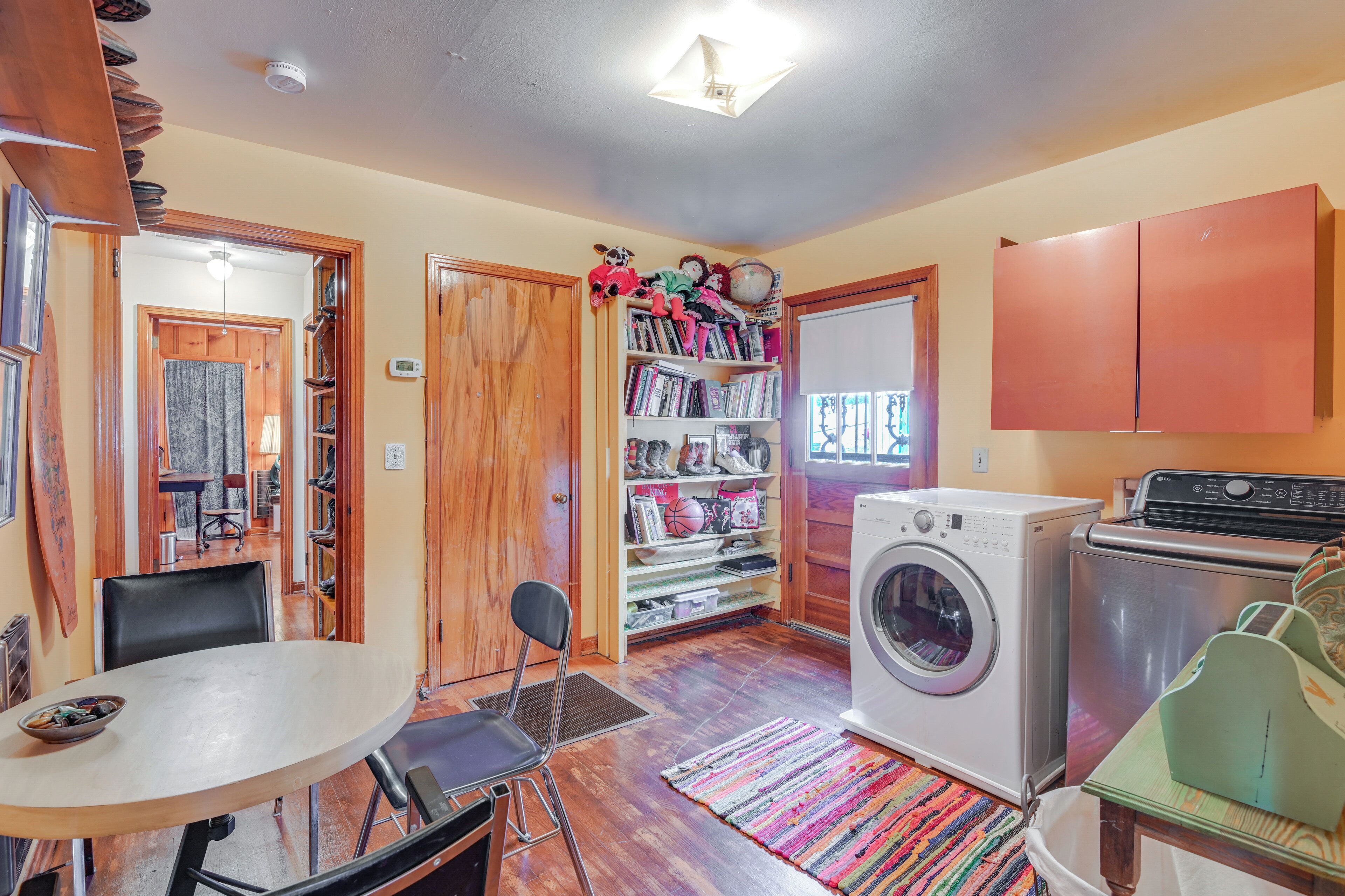 A compact laundry room with a washing machine, dryer, and a small table with chairs.