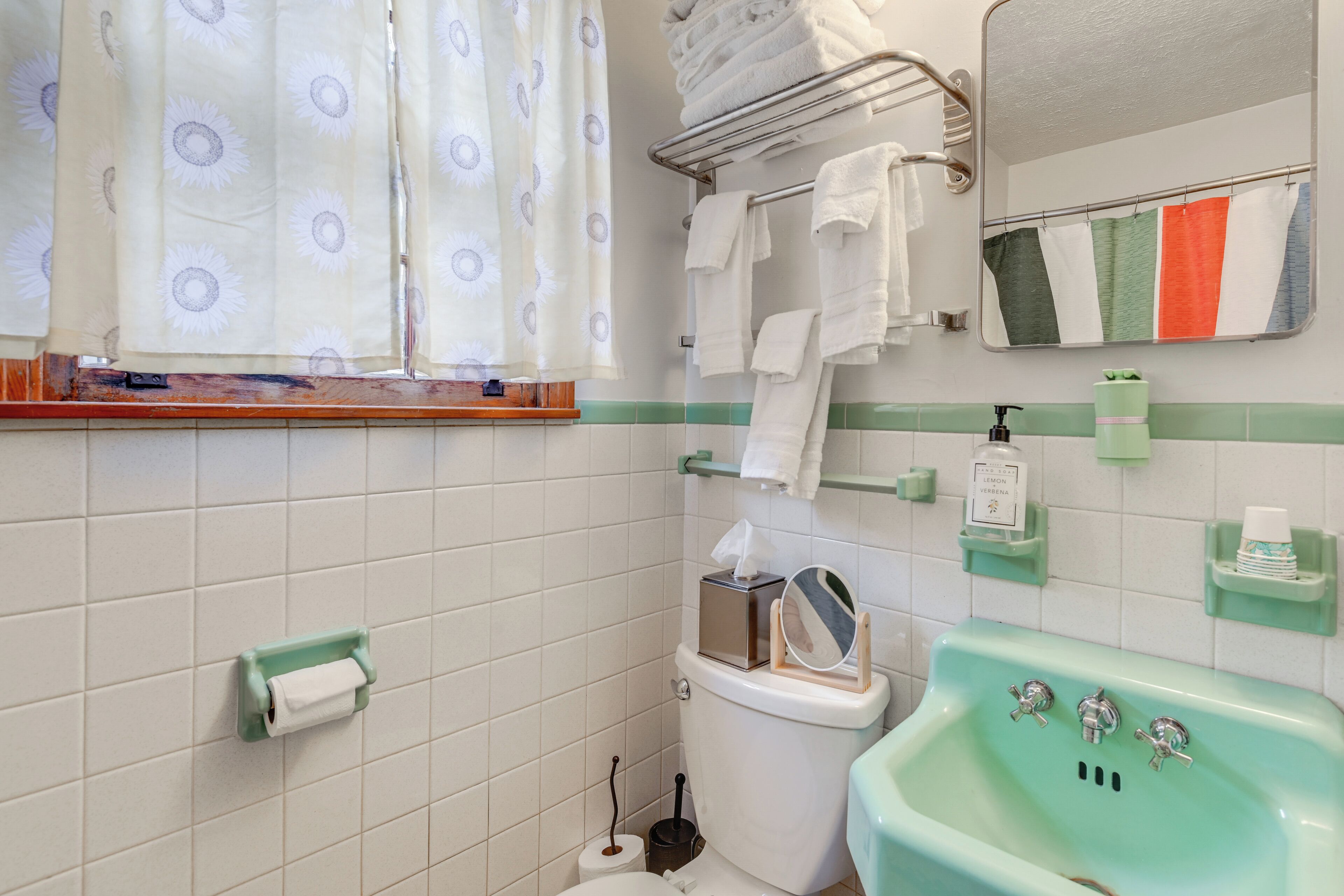 A bathroom with a toilet, sink, and towel rack.