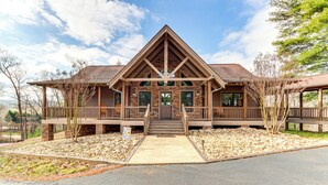 Eine Lodge mit markanter Holzkonstruktion, einer überdachten Veranda und einem Steinfundament.