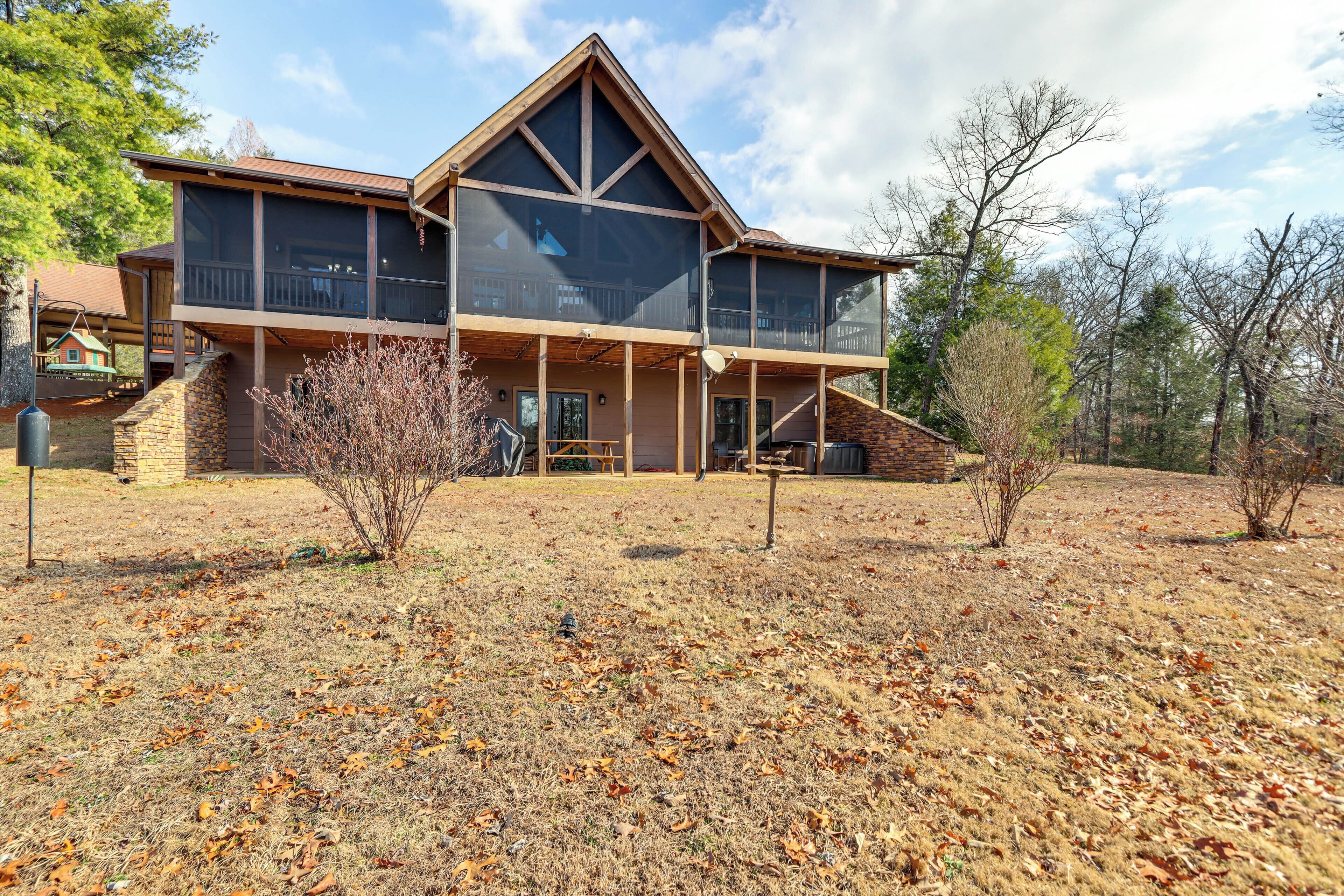 A large, modern two-story house with a prominent balcony and a wrap-around porch.