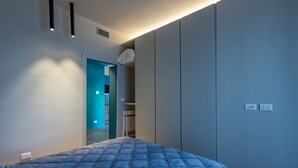Une chambre à coucher comprenant un lit, une armoire et une porte donnant sur une salle de bain.