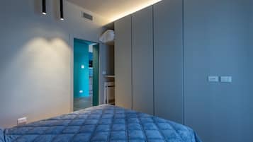 Una camera da letto con un letto, un armadio e una porta che conduce al bagno.