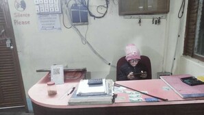 A reception desk with a 'Silence Please' sign, a QR code, a calculator, and some documents. - Bon Holong Resort  (Alipurduar)