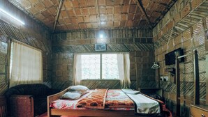 A room with a bed, a wooden cabinet, a television, and a window with curtains. - Bon Holong Resort  (Alipurduar)