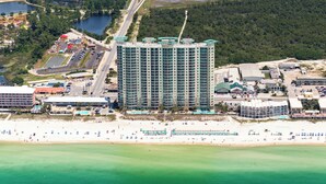 A high-rise hotel with a modern design, located near a beach and a parking lot. - Gulf-Front Bliss | Unique 2BR at Aqua Resort PCB (Panama City beach)