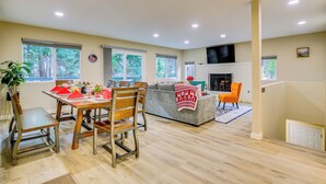 A spacious living area with a dining table, chairs, a sofa, and a fireplace.
