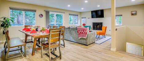A spacious living area with a dining table, chairs, a sofa, and a fireplace.