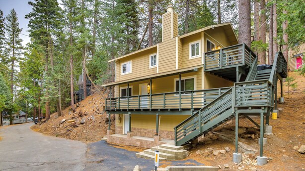 A two-story cabin with a balcony and a staircase leading to the upper level.