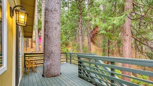 A wooden deck with a welcome mat, a bench, and a lantern.