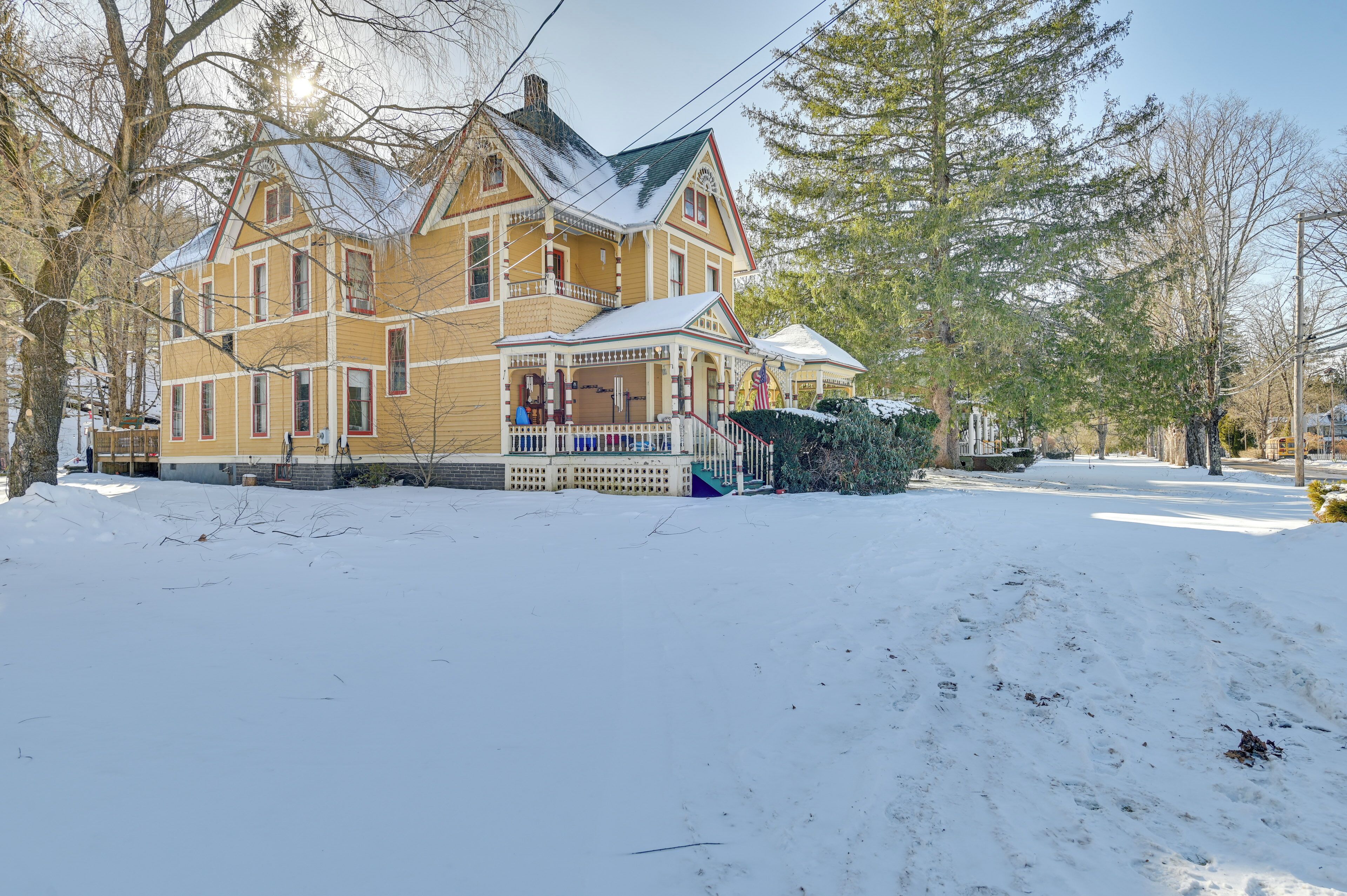 A large, two-story house with a porch and a snow-covered yard.