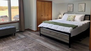 A bedroom with a bed, a window, a door, and a skylight. - Peaceful, Private Lakeside Home. Sleep 16! (Pentwater)