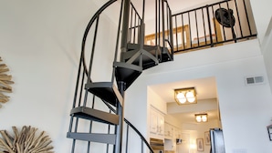 A modern spiral staircase with a metal railing, leading to a second-floor landing. - Million-dollar Views: Condo on Lake Hamilton! (Hot Springs)