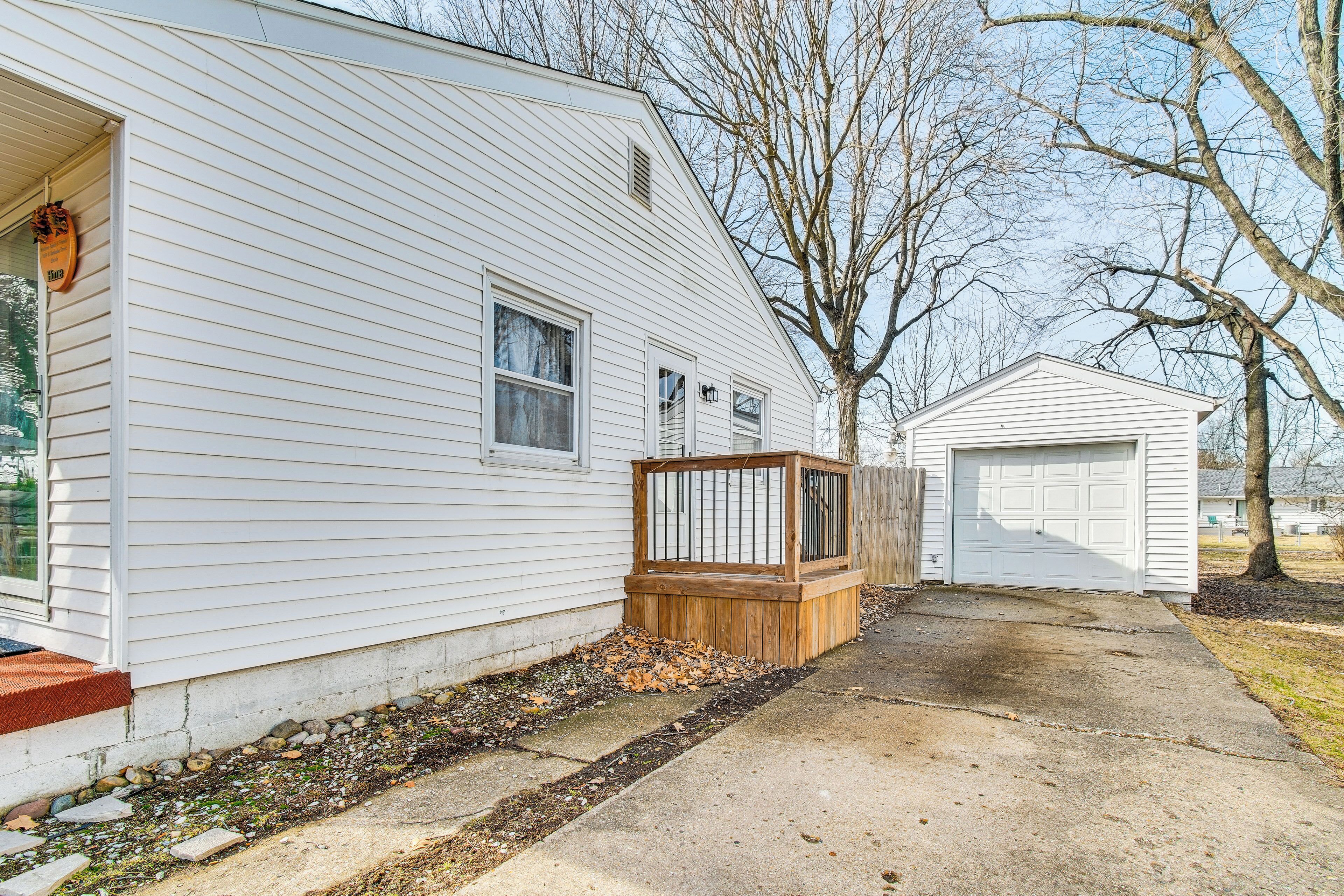 A white single-story house with a wooden deck and a garage.