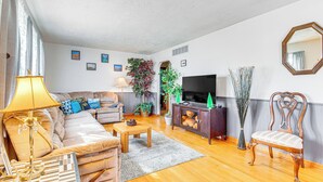 A living room with a sofa, a coffee table, a TV, and a decorative chair. - < 1 Mi to Route 66: Home w/ Large Yard! (Lincoln)