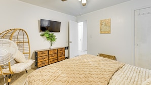A bedroom with a bed, a fan, a dresser, a television, and a door leading to another room. - Near Detroit Metro Area: New Baltimore Home! (New Baltimore)