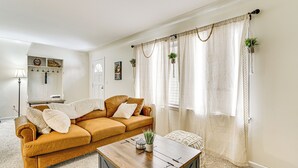 A living room with a brown sofa, a wooden coffee table, and a white lamp. - Near Detroit Metro Area: New Baltimore Home! (New Baltimore)