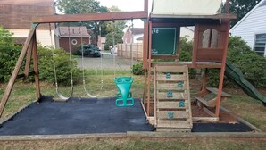 Un parque infantil con columpios, un tobogán y una estructura para escalar.