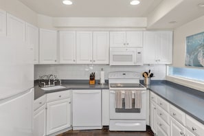 A modern kitchen with white cabinetry, a built-in microwave, and a stove. - 6 Bd, 5 Ba Telluride Condos on the River Trail, Connected, Sleeps 16 (Telluride)