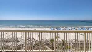 Une vue sur la plage depuis un balcon doté d’une balustrade.