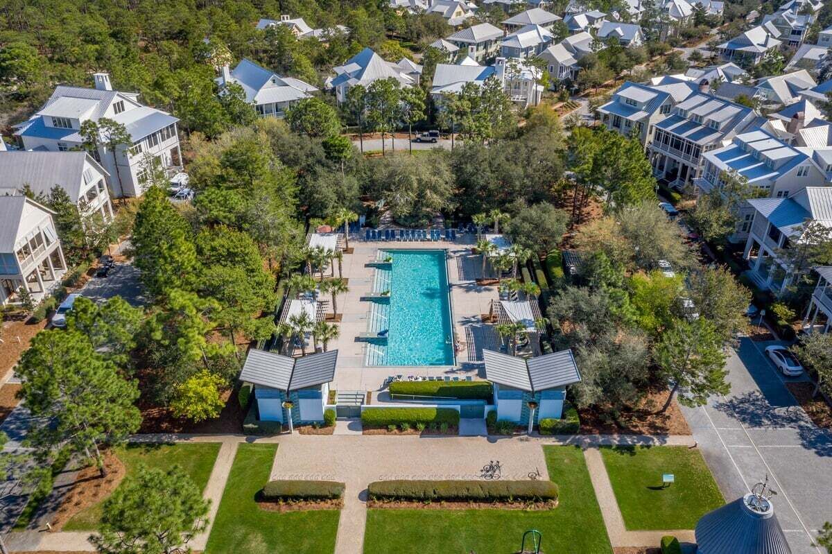 An aerial view of a residential area with a central swimming pool surrounded by houses.