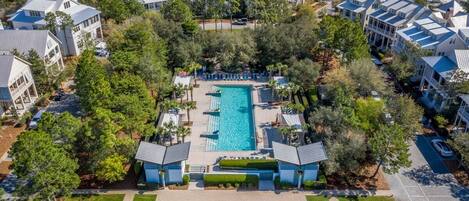 An aerial view of a residential area with a central swimming pool surrounded by houses.