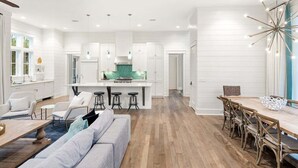 A modern kitchen with white cabinetry, a central island, and pendant lighting.