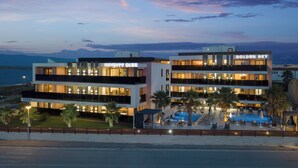 A modern hotel with multiple floors, a swimming pool, and a view of the mountains. - Malibu Imperial Resort (Vir)