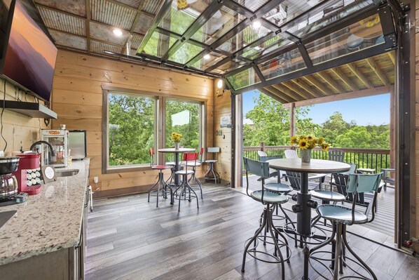 A wooden interior with a kitchen, dining area, and large windows.