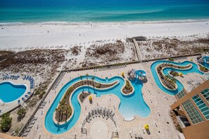 A resort with a large pool area, a beach, and a building with a modern design. - Phoenix Gulf Towers 1006 2 Bedroom Condo (Orange Beach)