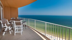 Un balcón con vistas al mar, amueblado con sillas y una mesa.